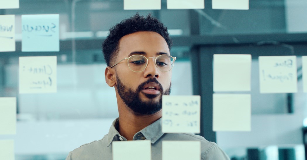 Youngbusinessmanusingadigitaltabletduringabrainstormingsessioninamodernoffice