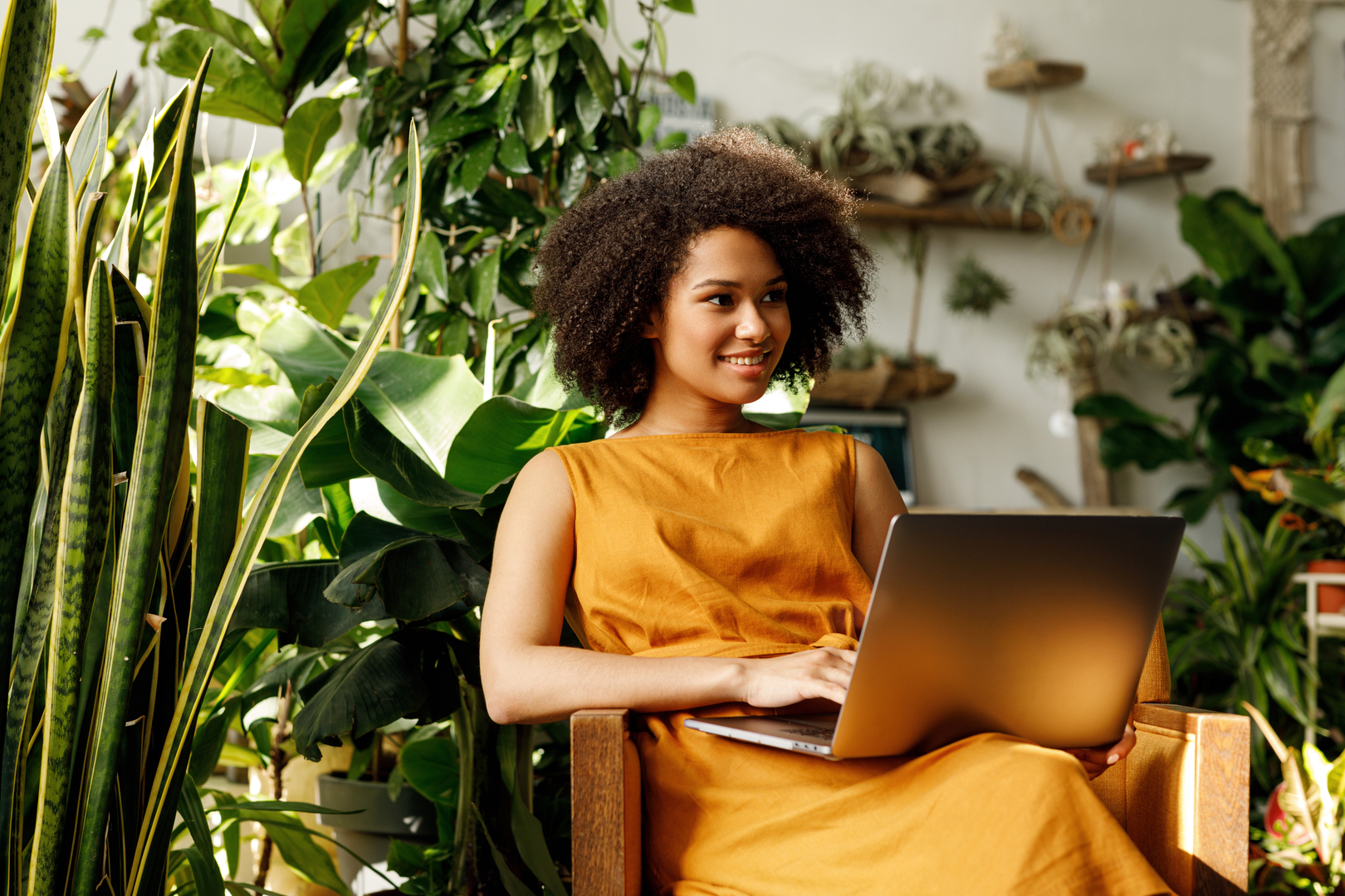 Youngwomanusingcomputerwhilesittingnexttoplants
