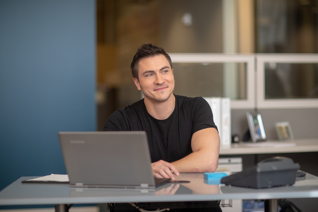 Person seated at a desk using a laptop in a modern office.