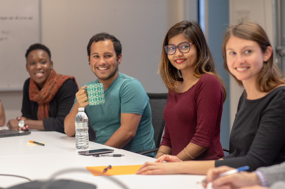 Group of colleagues seated at a table during a meeting.