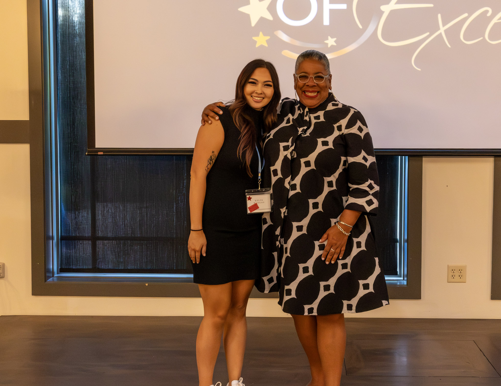 Two people standing together on a stage during an awards event.