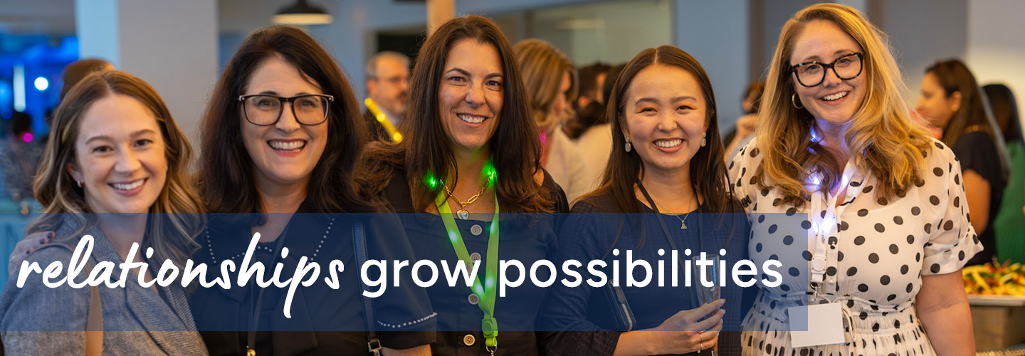 A group of people standing together in a brightly lit indoor setting with a food table in the background, featuring text that reads “relationships grow possibilities.”