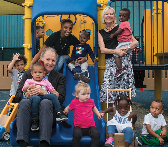 Co-founders of Bright Horizons smiling with a group of children.