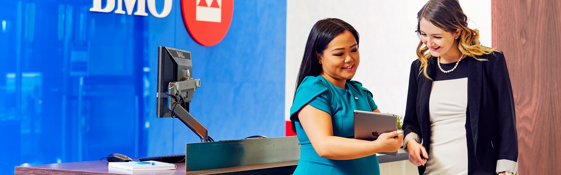 Two female employees looking at an iPad.