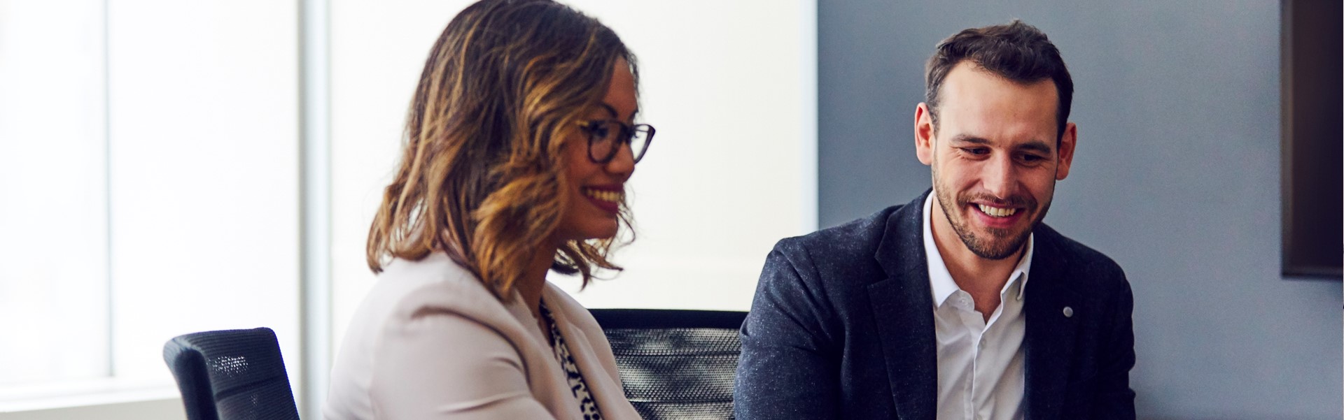 Two employees discussing at a meeting. 