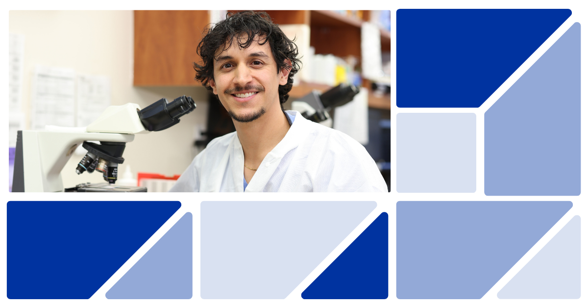 Laboratory Associate smiling while next to microscope in lab