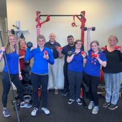 Therapy team at St. Francis Therapy Center in Simpsonville gathered in a rehab space, holding weights and resistance bands