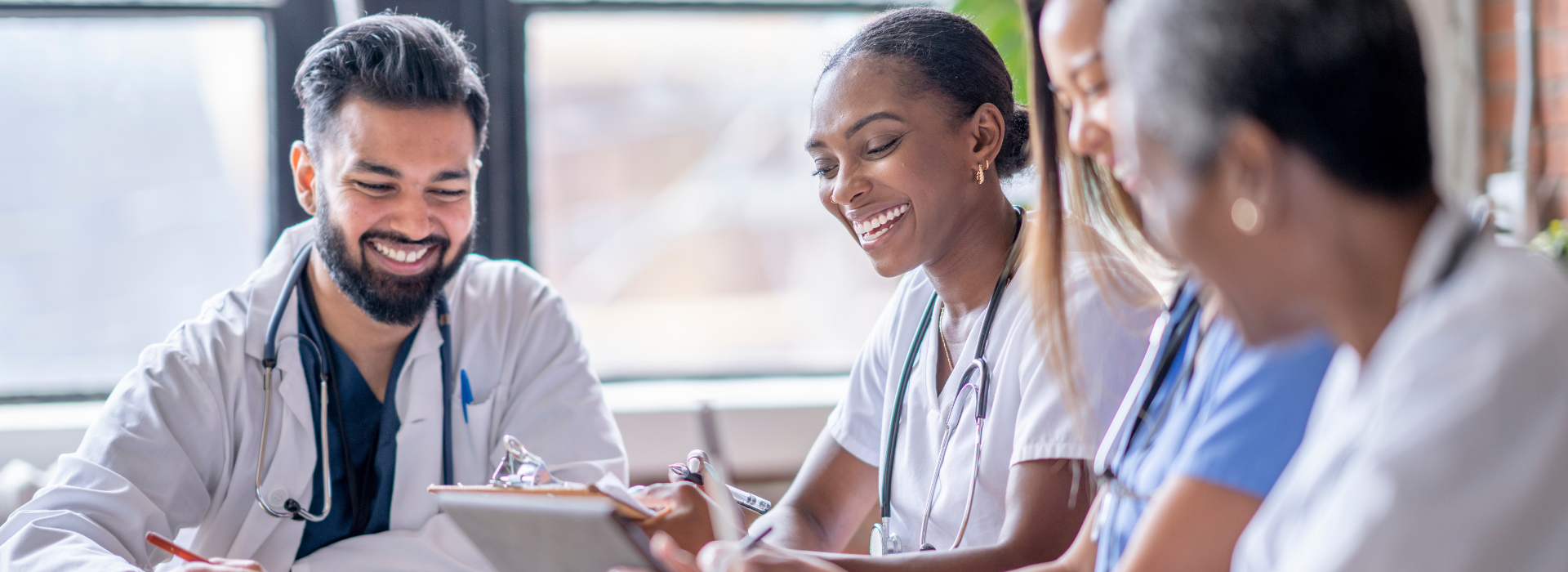 Group of medical professionals laughing while looking down at agenda
