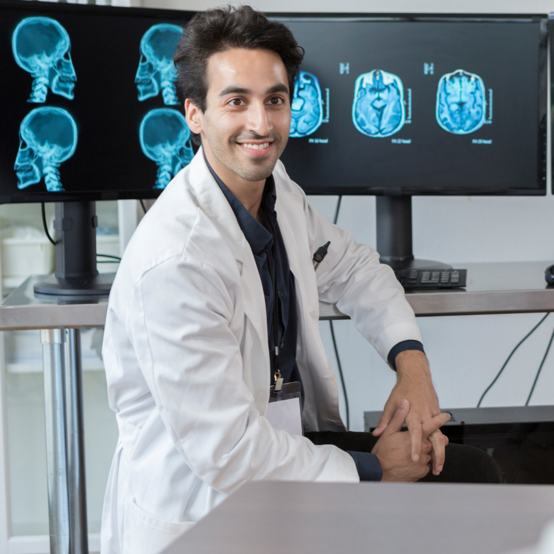 Imaging teacher facing the class with xrays on the computer screen behind him