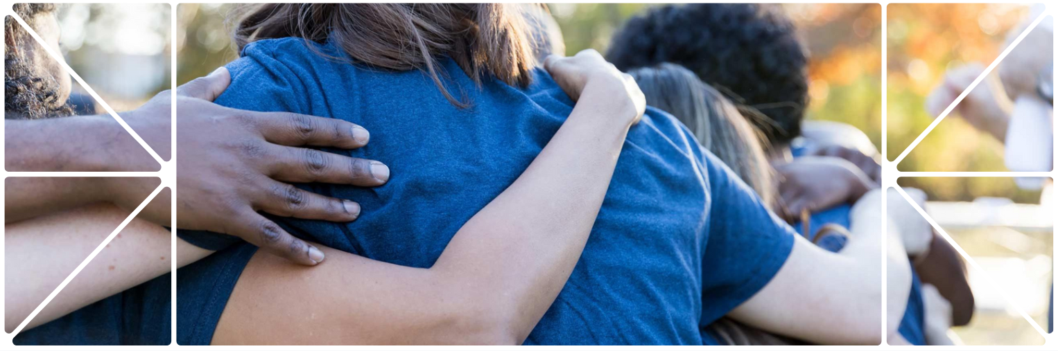 Close-up of a group hug with arms wrapped around one another, wearing matching blue shirts. The image is framed with a white geometric brand pattern, evoking connection and community.