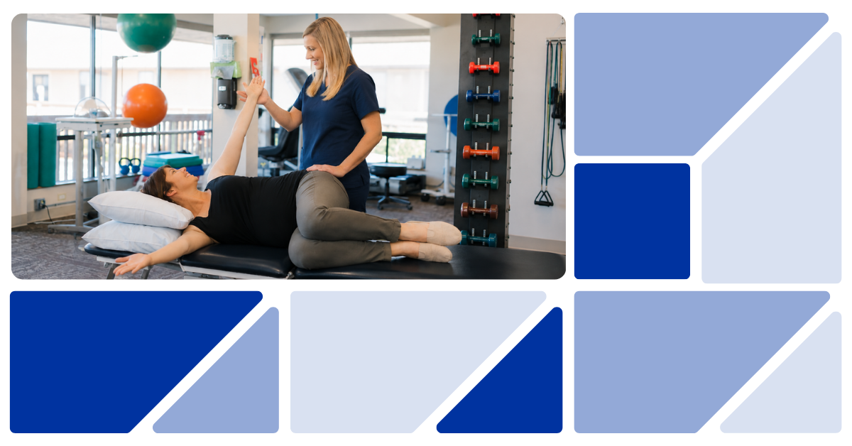 Physical therapist in dark blue scrubs guides a patient through a stretching exercise on a treatment table.