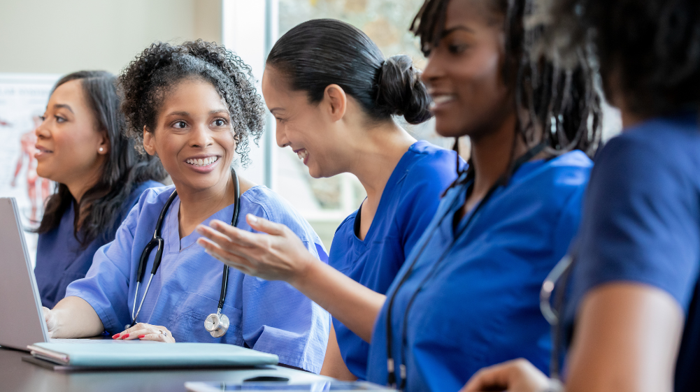 Student nurse in blue scrubs smiling