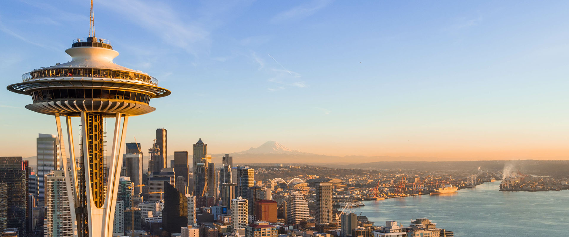 Aerial shot of Seattle, featuring the Space needle in the foreground and the city in the background.