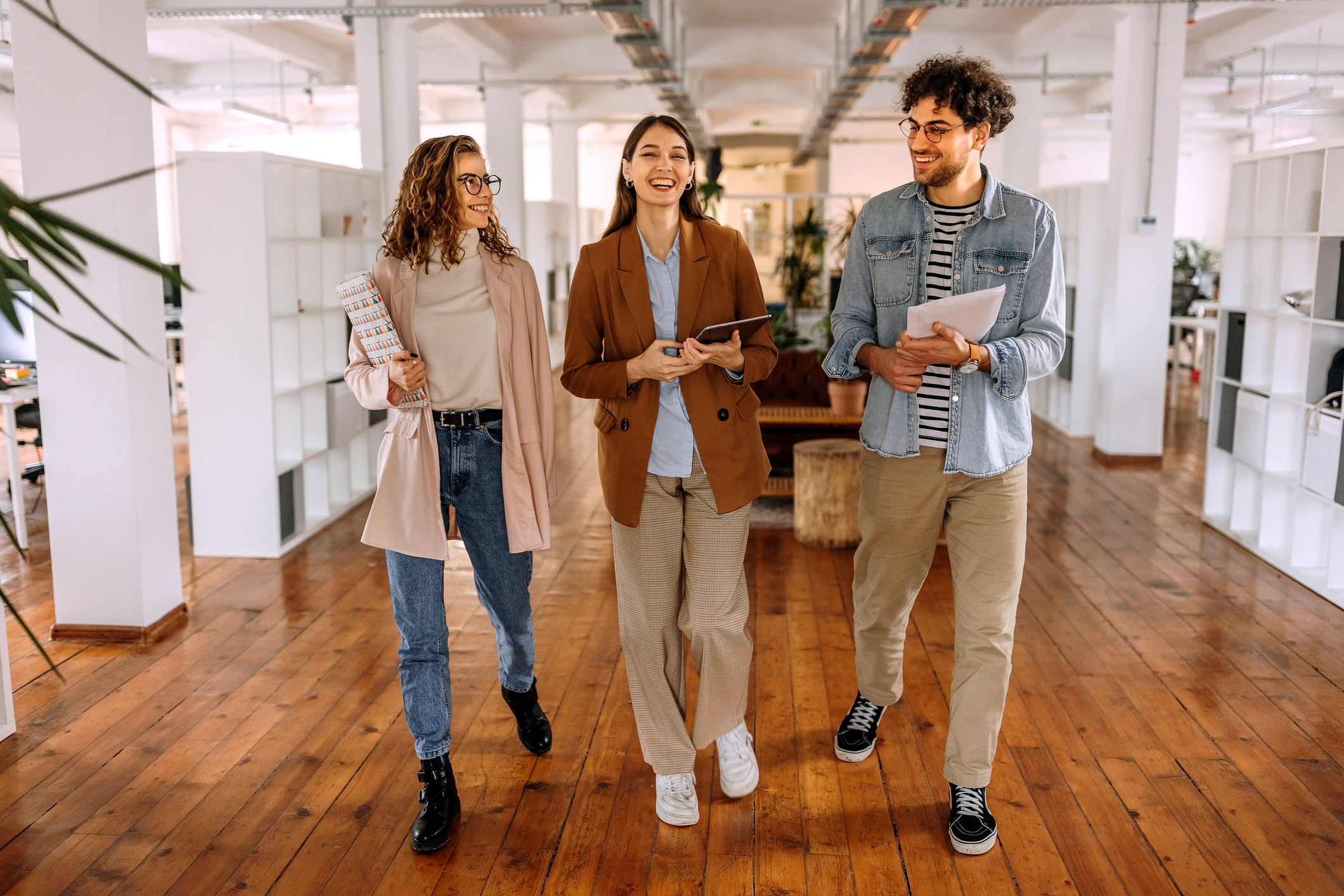 group-young-colleagues-walking-through-modern-office