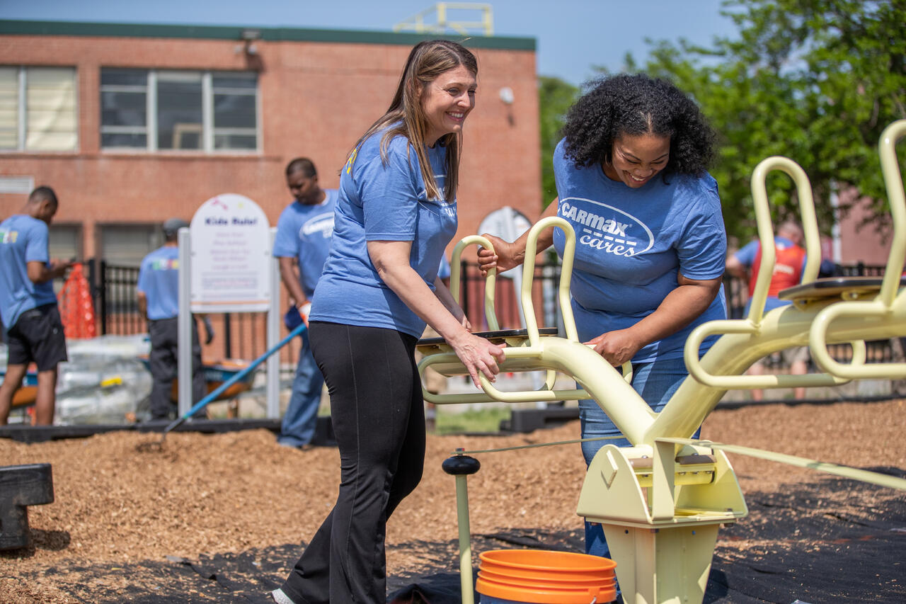 Two female employees building playgrounds in partnership with KABOOM!