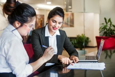 two professional women looking at a document