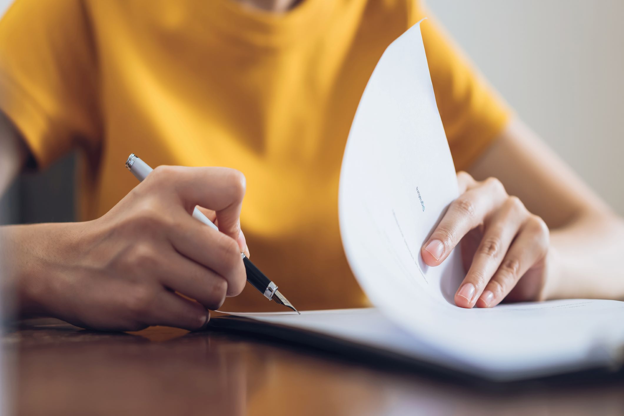 close up on a woman signing a document