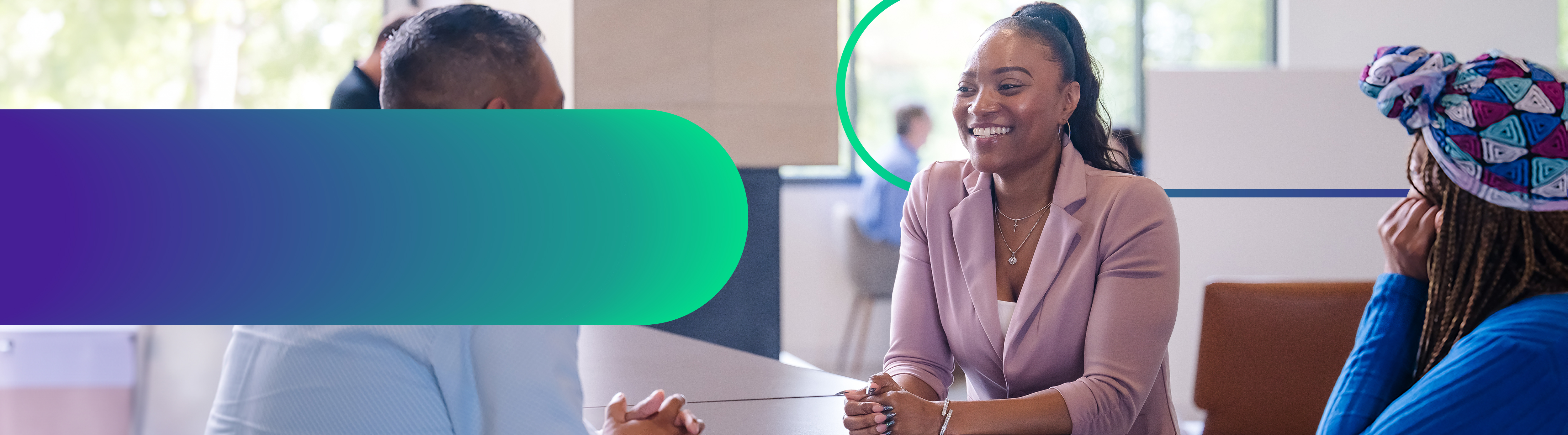 Cencora team members sit and converse in a brightly naturally lit open office space.