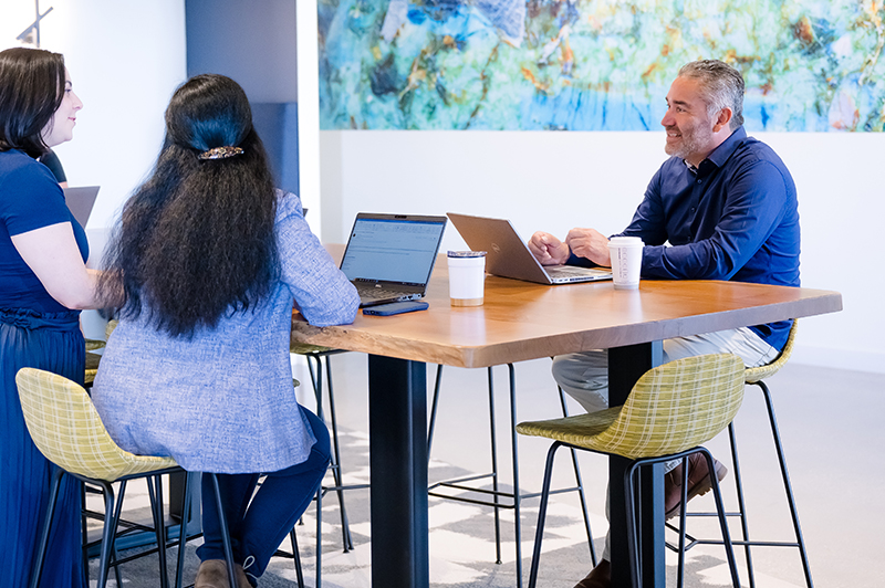 A member of the Unidos ERG sits in one of Cencora's collaboration spaces and talks with other team members.