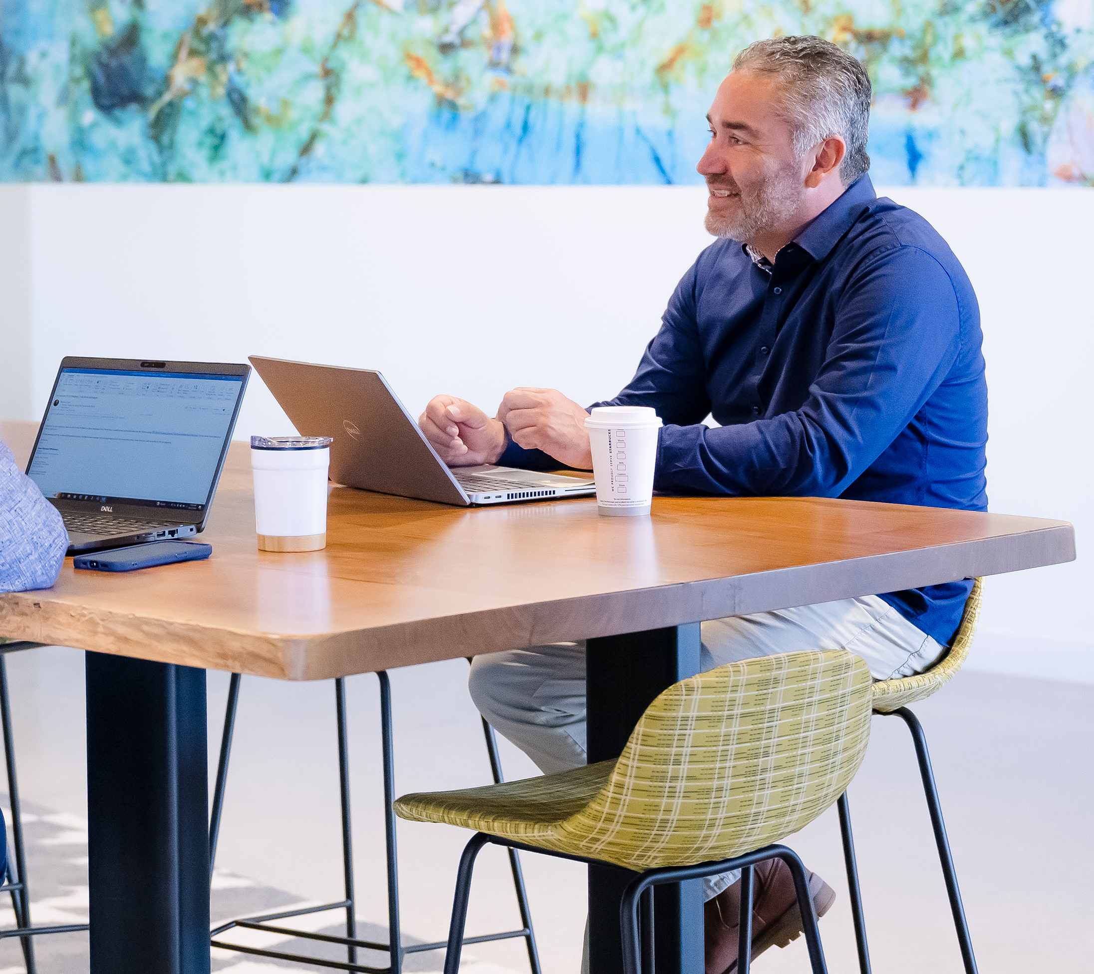 A member of the Unidos ERG sits in one of Cencora's collaboration spaces and talks with other team members.