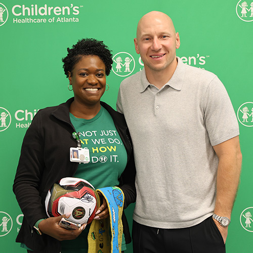 A Children’s administrative team member joins former Atlanta United soccer player Brad Guzan at an employee recognition event. 