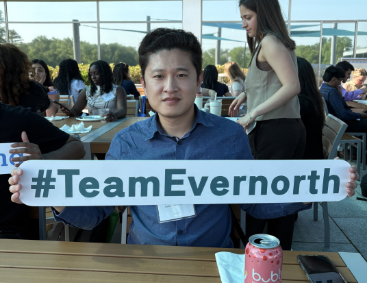 Employee holding #TeamEvernorth Sign