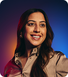 An East Asian woman with long dark hair and wearing a shiny brown blouse smiles and looks to her left.