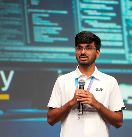A participant holding a microphone, presenting to an audience