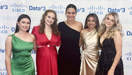 A group of young women in formal wear in front of a Data#3 Cisco backdrop.