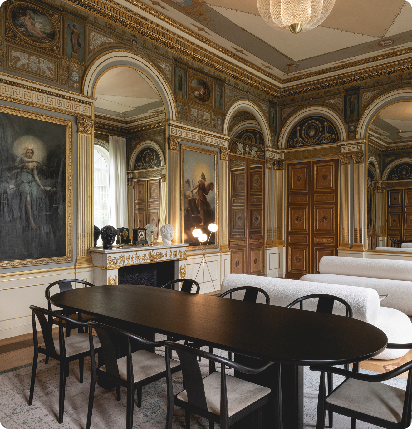 A Rococo-style room that features a modern conference table and couches.