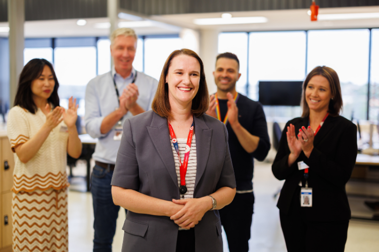 A female team member being applauded by their colleagues in the Coles Store Support Centre