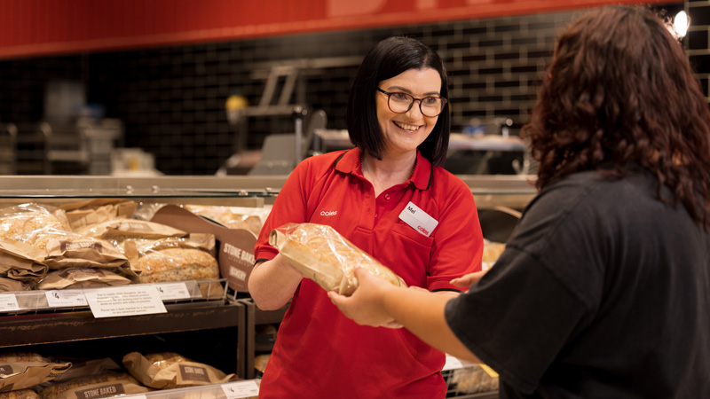 A Coles team member helping a customer with coffee