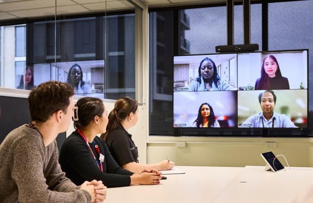 Coles corporate employees sitting in a hybrid meeting