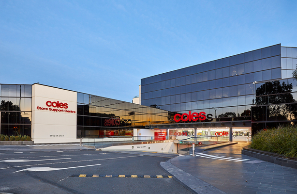 Exterior view of a Coles Store Support Centre building with signage and driveway entrance.