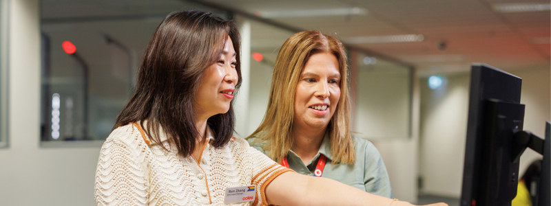 Two female corporate team members working together in Coles Store Support Centre