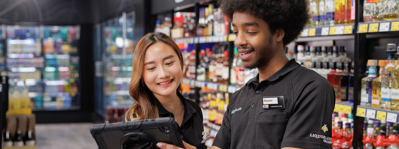 A female and male Liquorland team members using an tablet instore