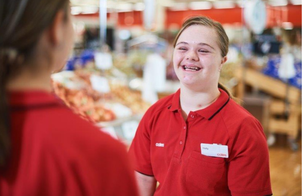 A female team member with a disability talking to another female team member