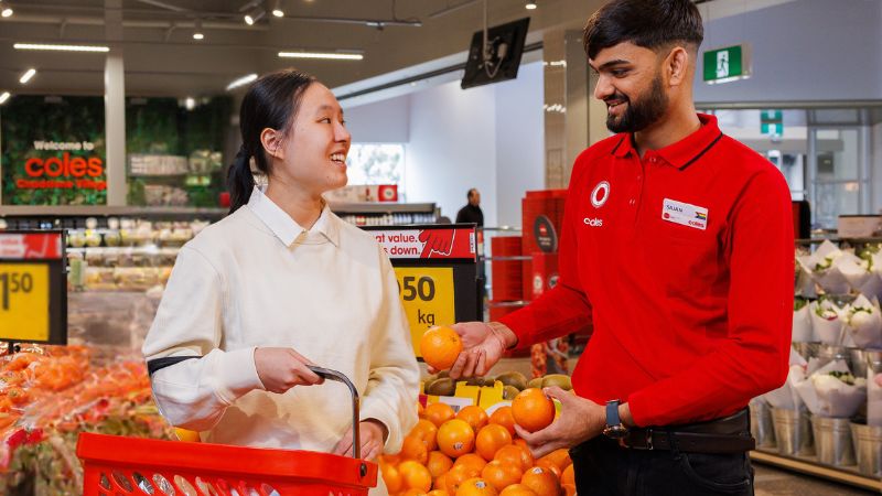 Male team member helping a customer in fresh produce