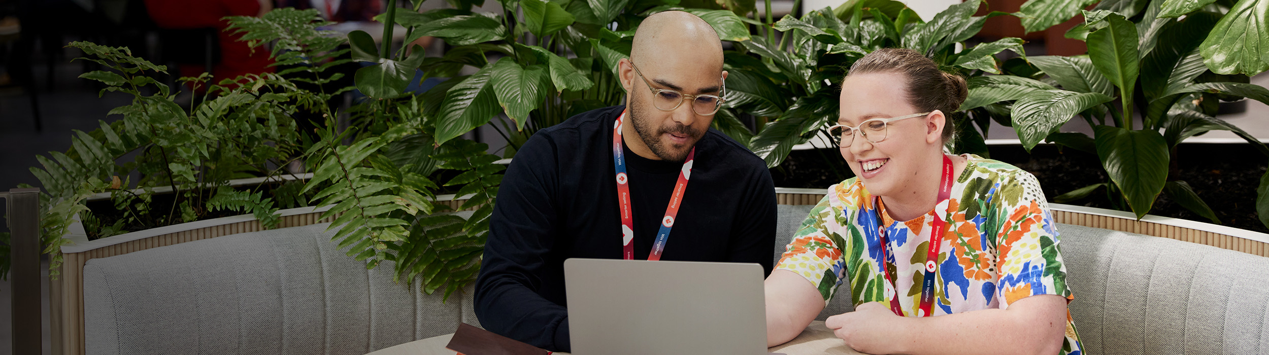 Coles employees sitting at a laptop