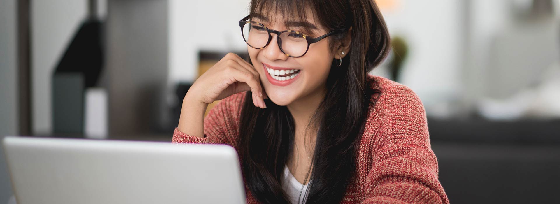 Female employee looking at laptop and smiling