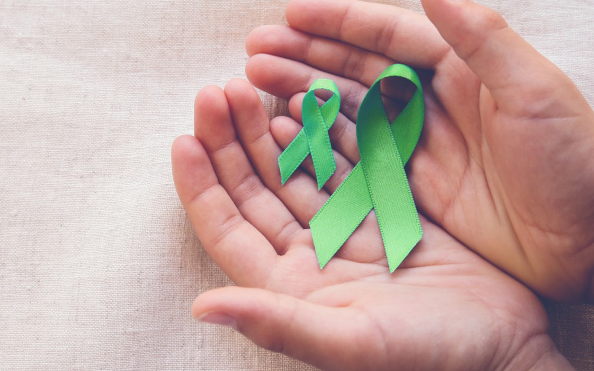 hands holding green ribbons.