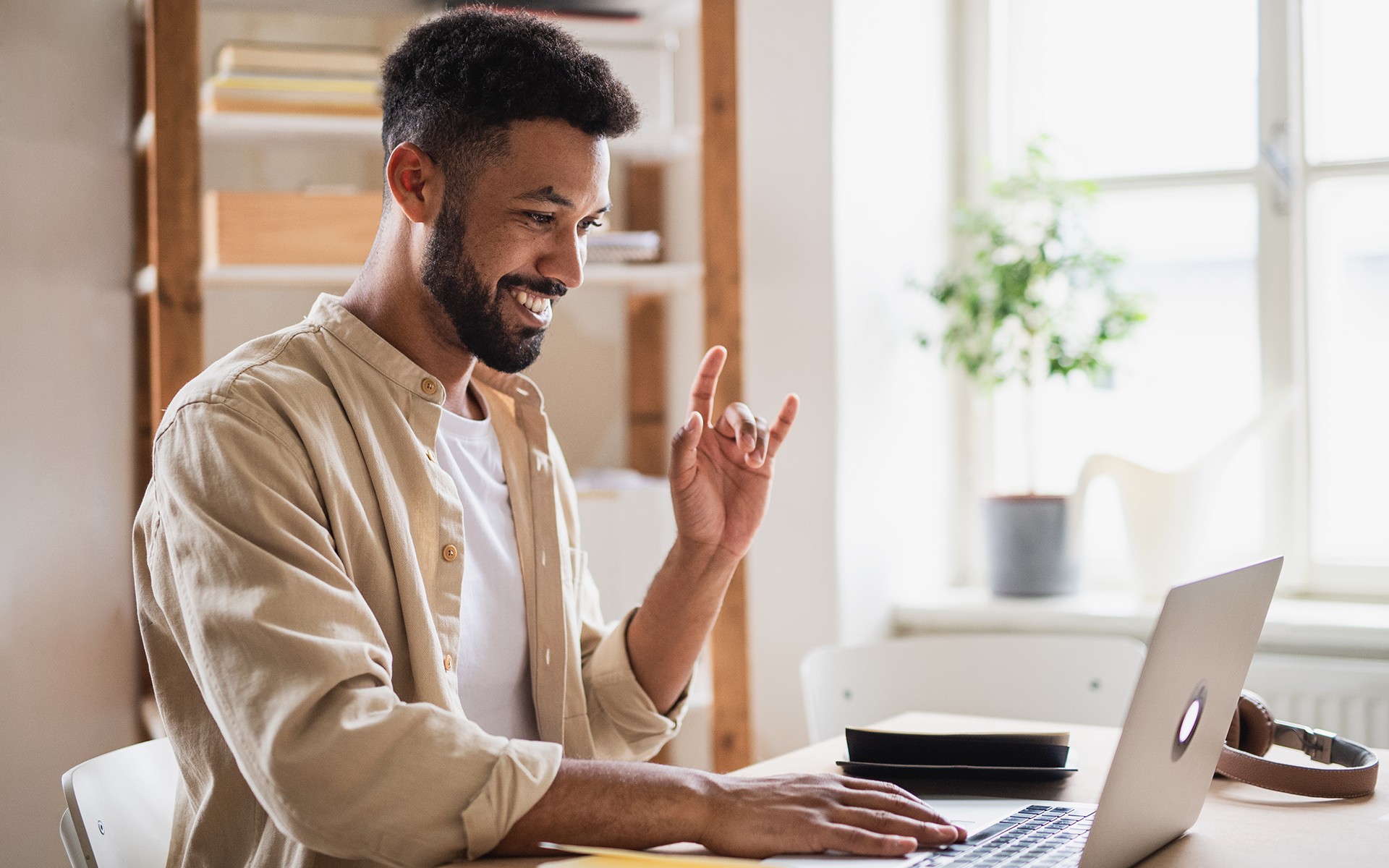 A young deaf man uses sign language to interact with the computer.