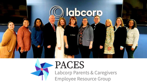 Eleven individuals stand in a line in front of a blue wall featuring the Labcorp logo, posing for a photo during the PACES ERG launch event. 