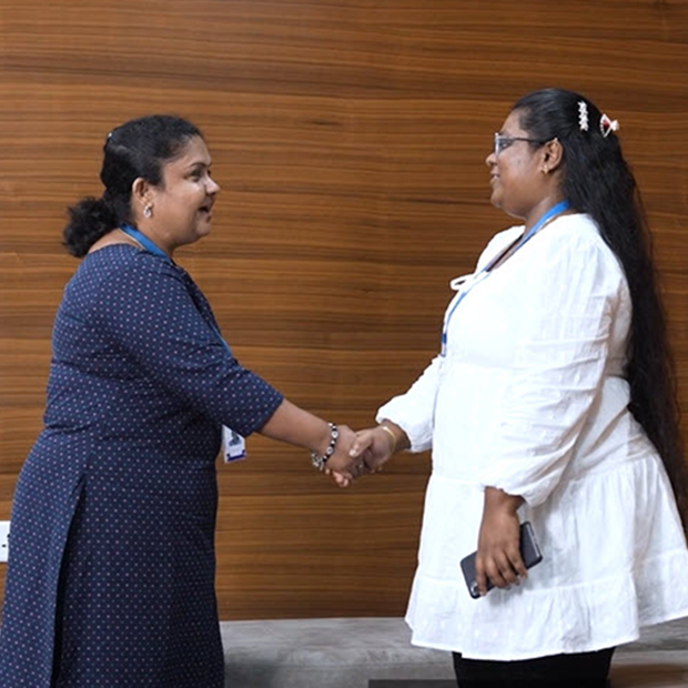 A staff member meets and applicant and shakes hands.