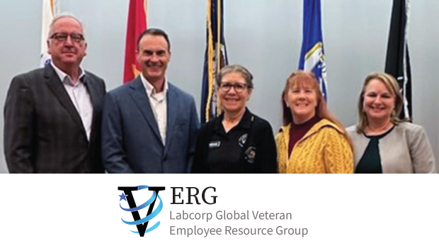 Verg ERG members pose in front of flags.