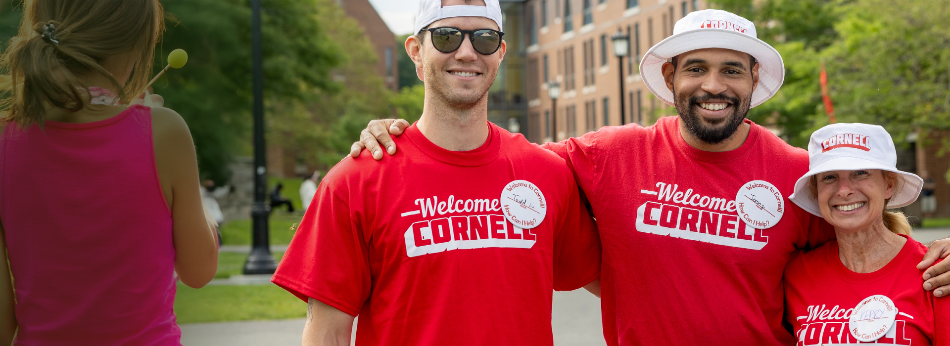 three colleagues volunteering at Cornell move-in day, wearing Cornell tshirts & hats