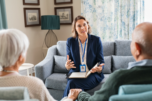 Person sitting on couch chatting with elderly patients at home