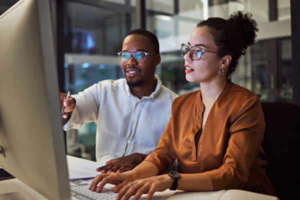 Two team members sitting in front of a computer 