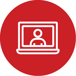 A simple white icon of a person on a laptop screen is centered within a red circle. The icon is minimalist and symbolizes video calls or online communication.