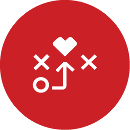 A white icon on a red circular background. The icon consists of a circle, two Xs, an arrow leading from the circle to a heart, and a curved line connecting them, resembling a playful strategy game or plan.